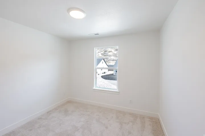 Spare room with light colored carpet and baseboards