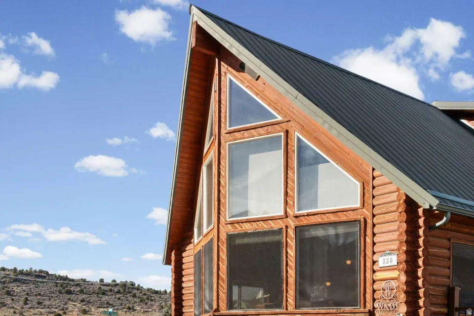 View of side of property with a metal roof, log siding, and a standing seam roof