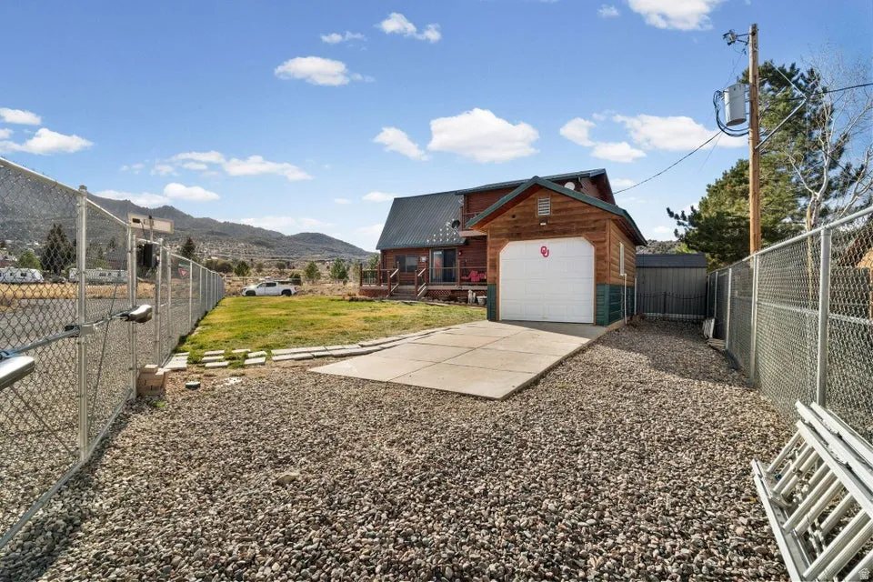 Fenced yard with a mountain view and concrete driveway