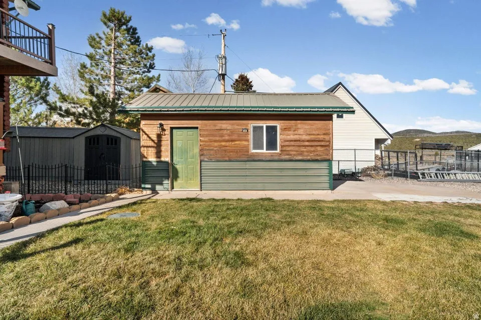 Back of property with a storage shed and a metal roof