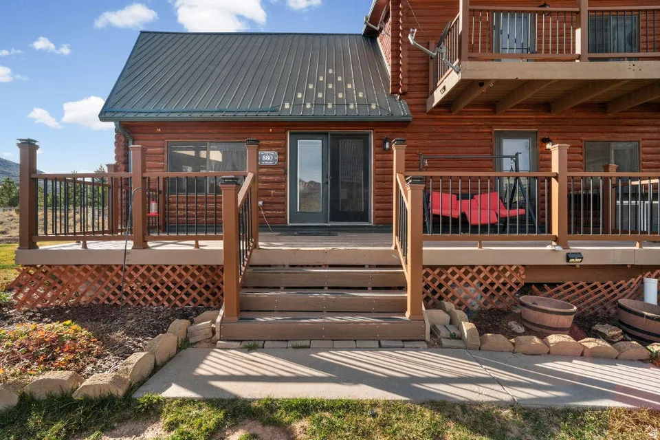 Back of house with a metal roof, a deck, and a balcony