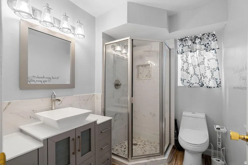 Full bathroom featuring vanity and a marble finish shower