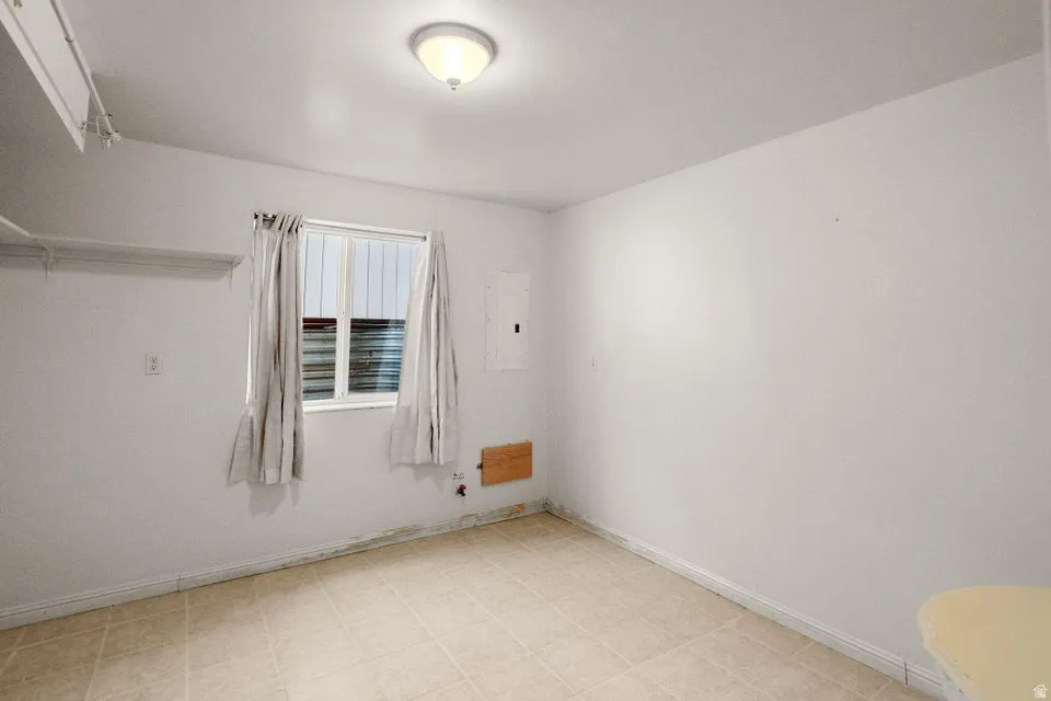 Empty room with electric panel and light floors