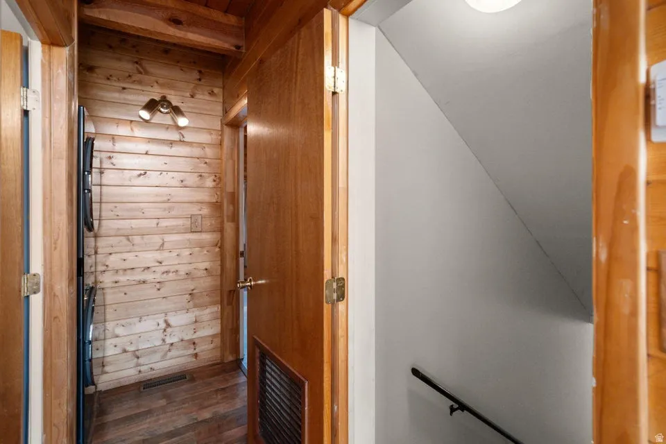 Hallway featuring wooden walls