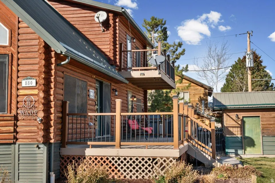View of home's exterior with a balcony, log exterior, and a wooden deck