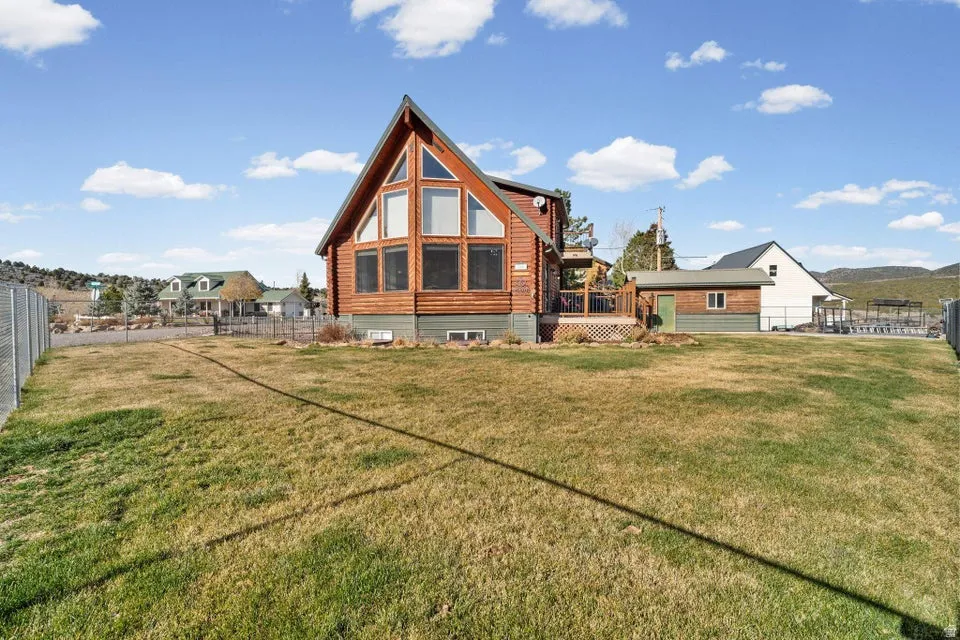 Rear view of property with a fenced backyard and a deck