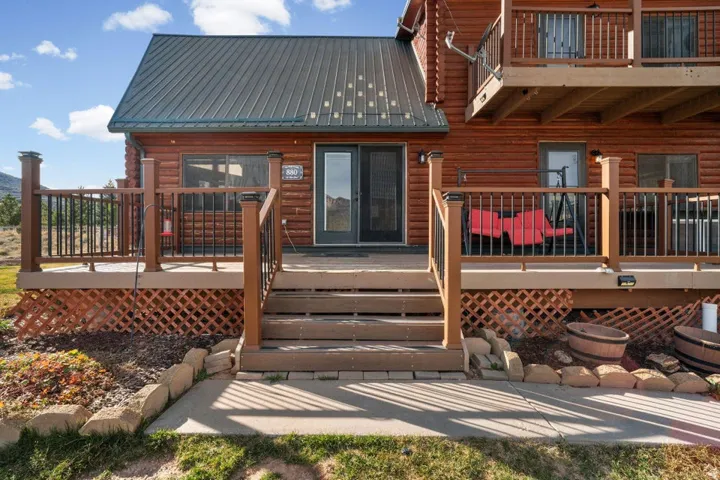 Back of house with a metal roof, a deck, and a balcony