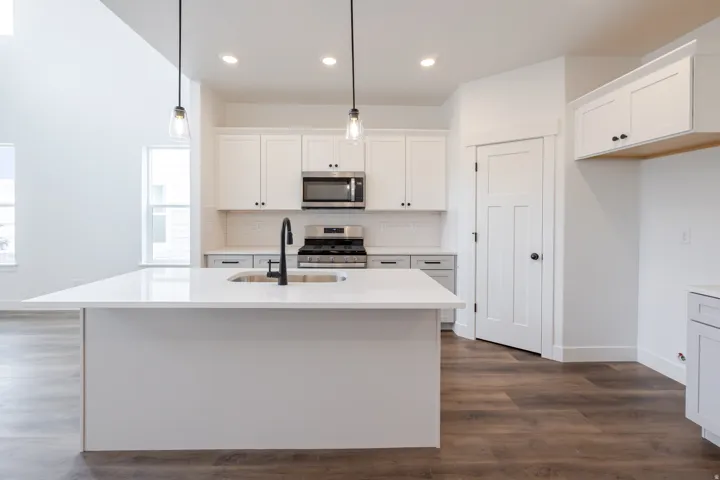 Kitchen with white cabinets, stainless steel appliances, an island with sink, and healthy amount of natural light