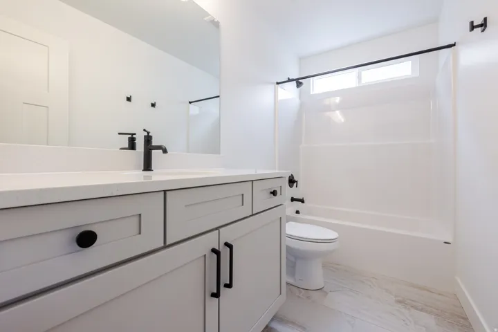 Full bath featuring vanity, bathing tub / shower combination, and light marble finish flooring