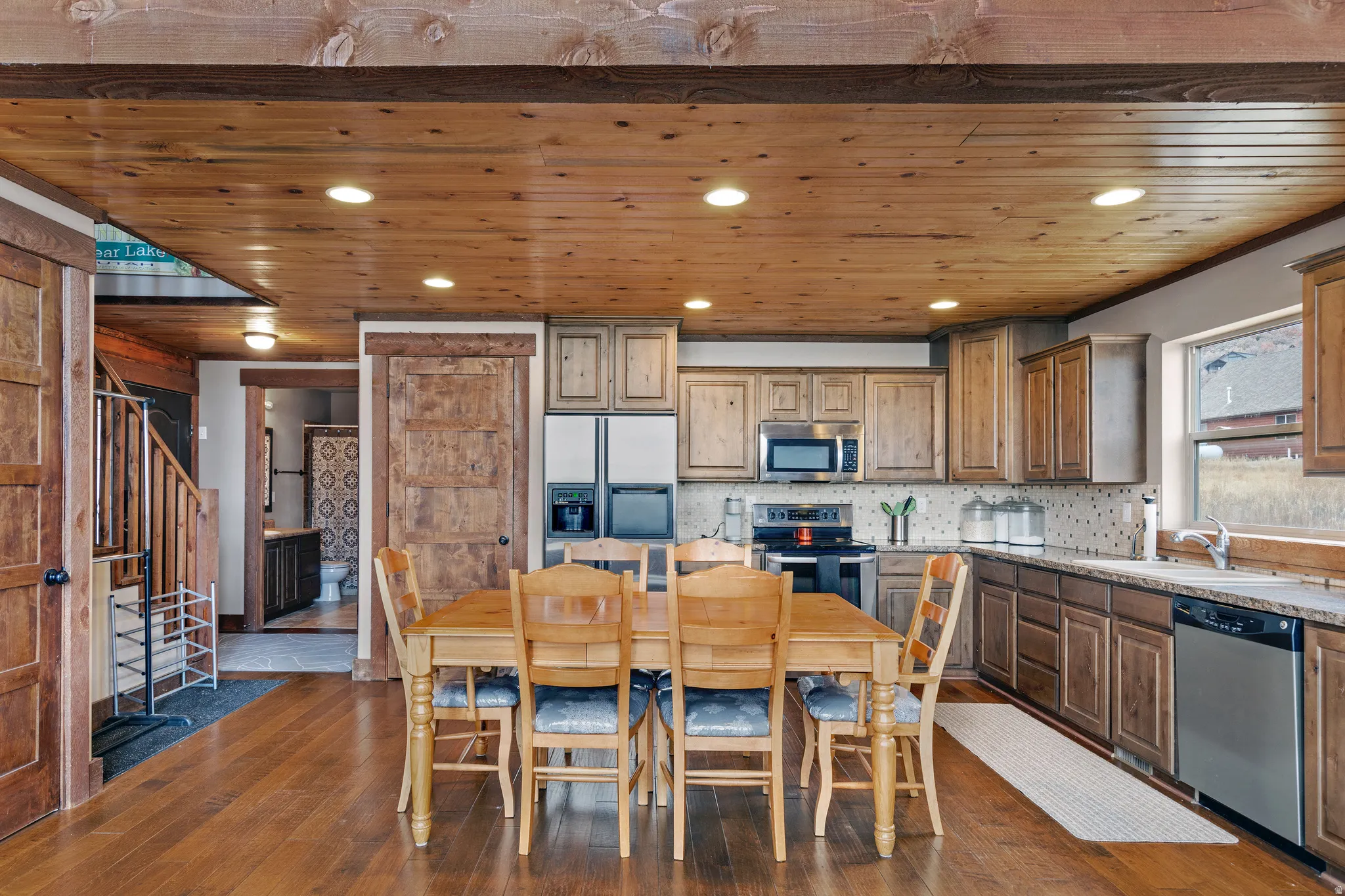 Kitchen featuring stainless steel appliances, dark wood-type flooring, backsplash, wooden ceiling, and recessed lighting