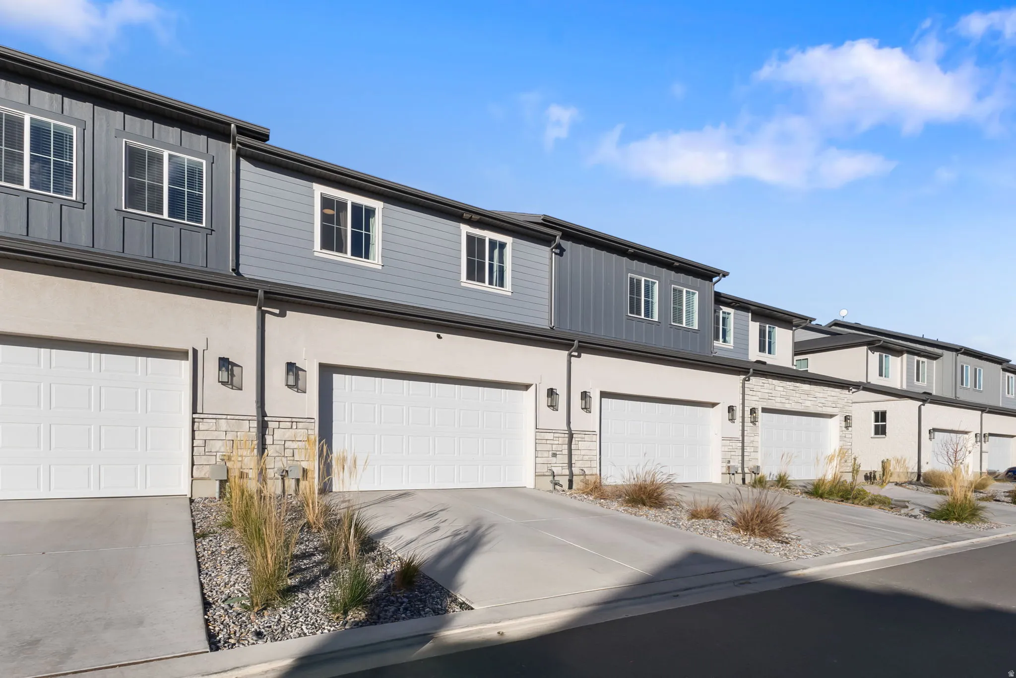 Traditional-style house featuring stone siding, driveway, and a residential view
