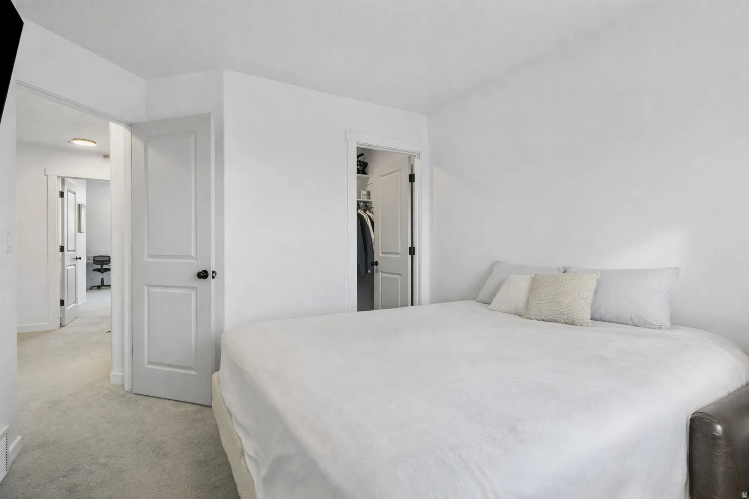 Bedroom featuring a spacious closet and light carpet
