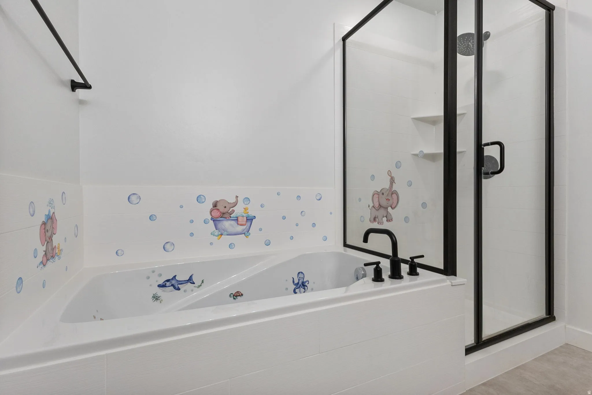 Bathroom with a tub with jets and a stall shower