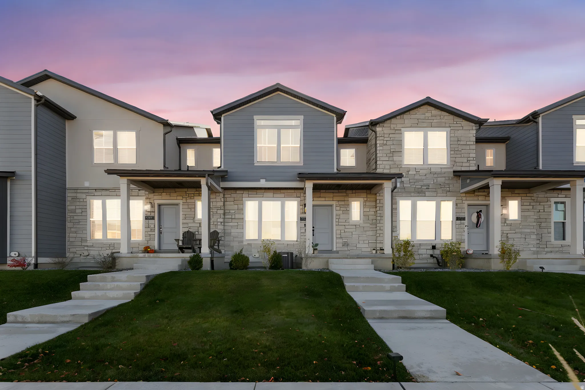 View of front of house featuring stone siding, a front yard, and a porch
