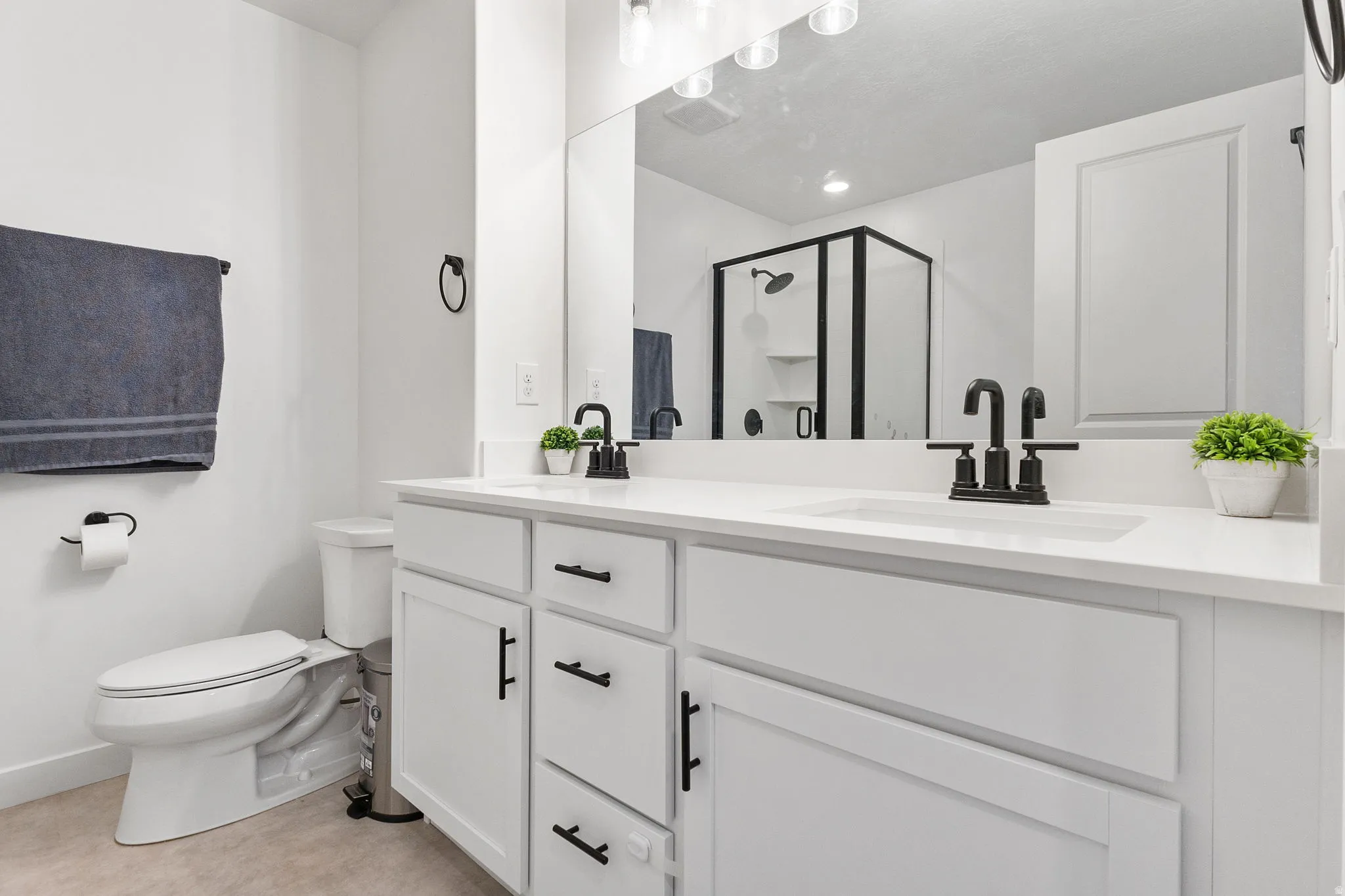 Bathroom with a shower stall and double vanity