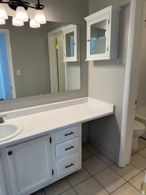 Bathroom with vanity, light tile patterned flooring, and shower / washtub combination
