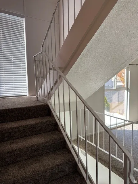 Staircase featuring a textured ceiling