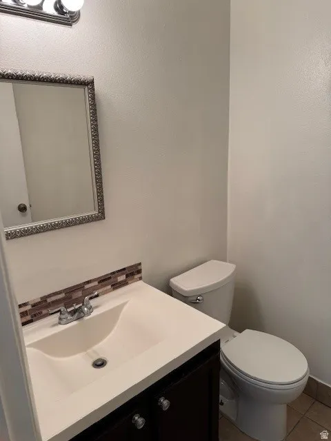 Bathroom featuring vanity, tile patterned flooring, and backsplash