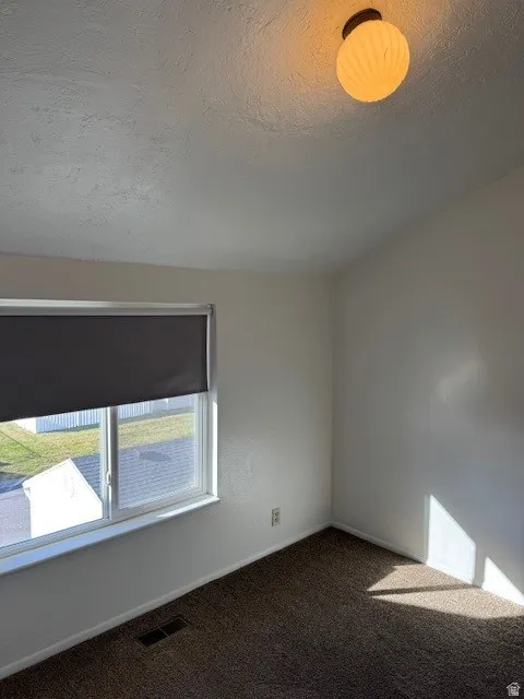Bedroom featuring carpet floors and a textured ceiling