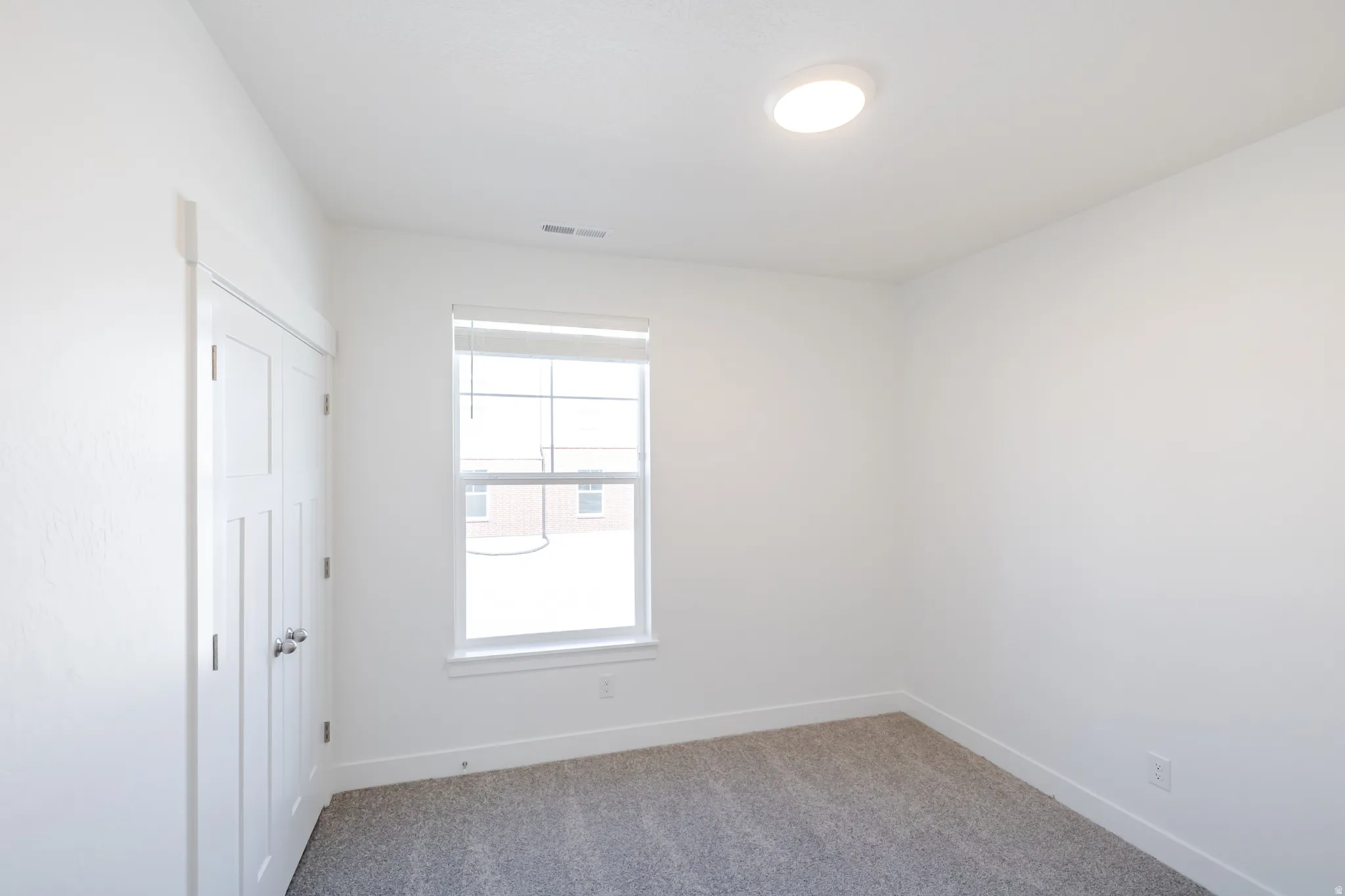 Empty room featuring light carpet and baseboards