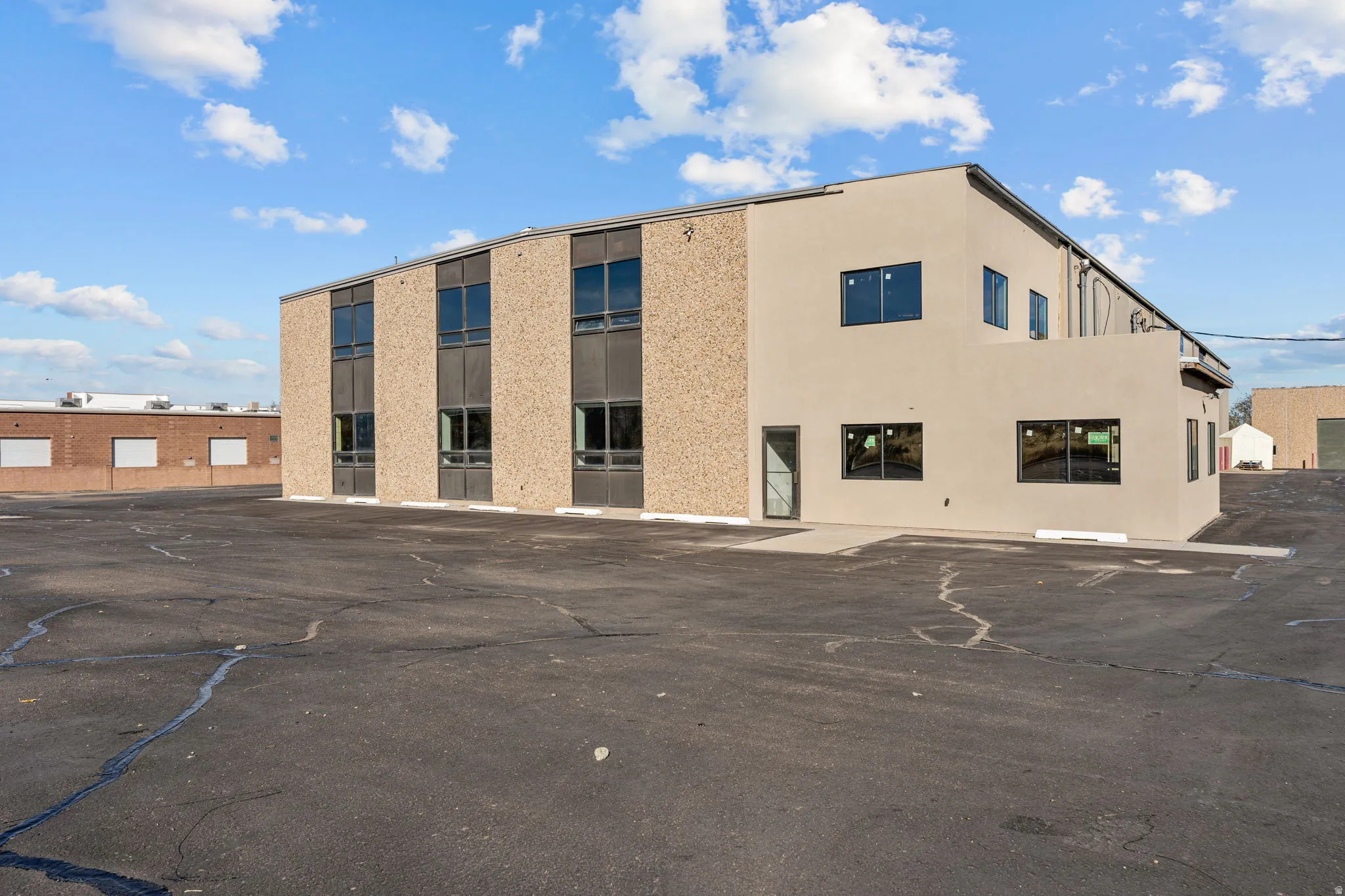 View of building exterior with uncovered parking