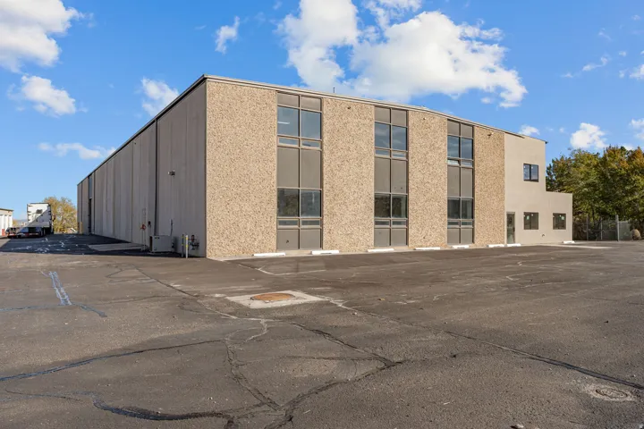 View of building exterior featuring uncovered parking