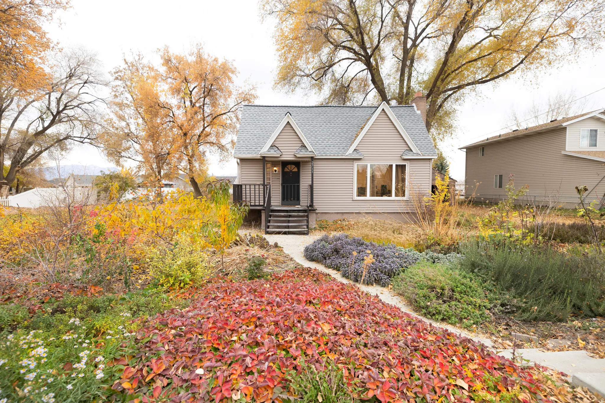 Bungalow-style house featuring roof with shingles and a chimney