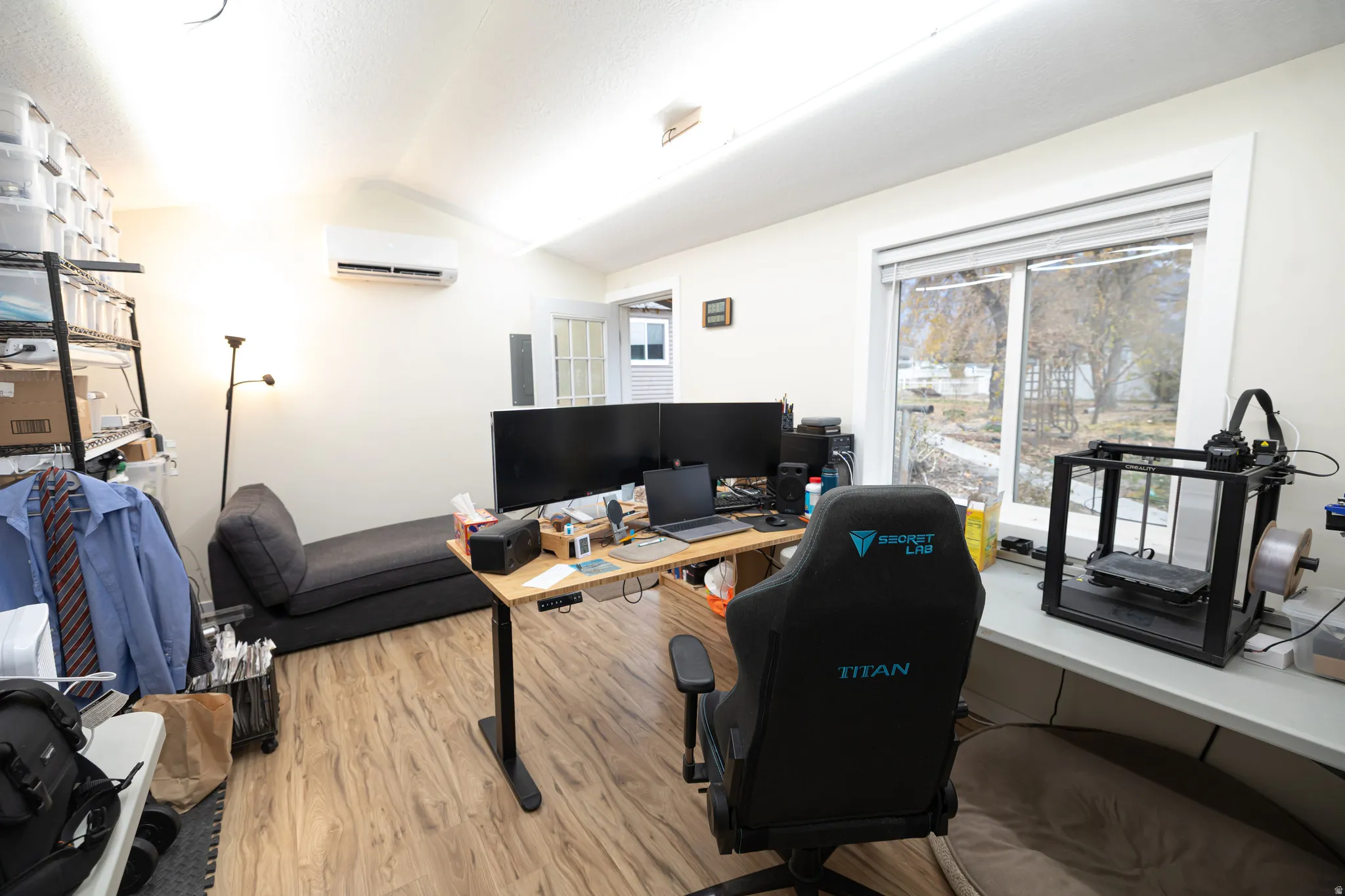 Office space featuring lofted ceiling, wood finished floors, and a wall unit AC