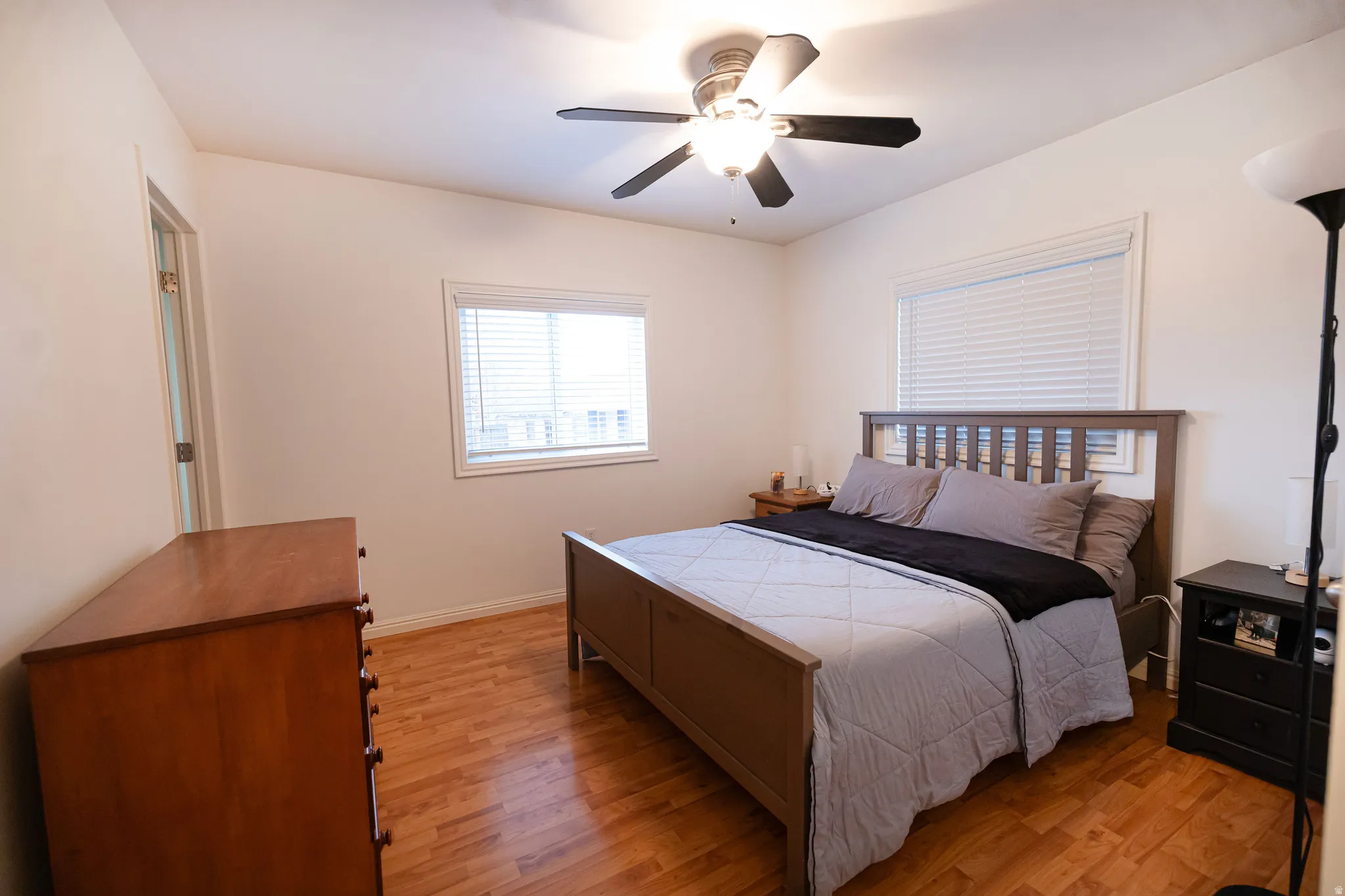 Master bedroom with light wood-style flooring and ceiling fan