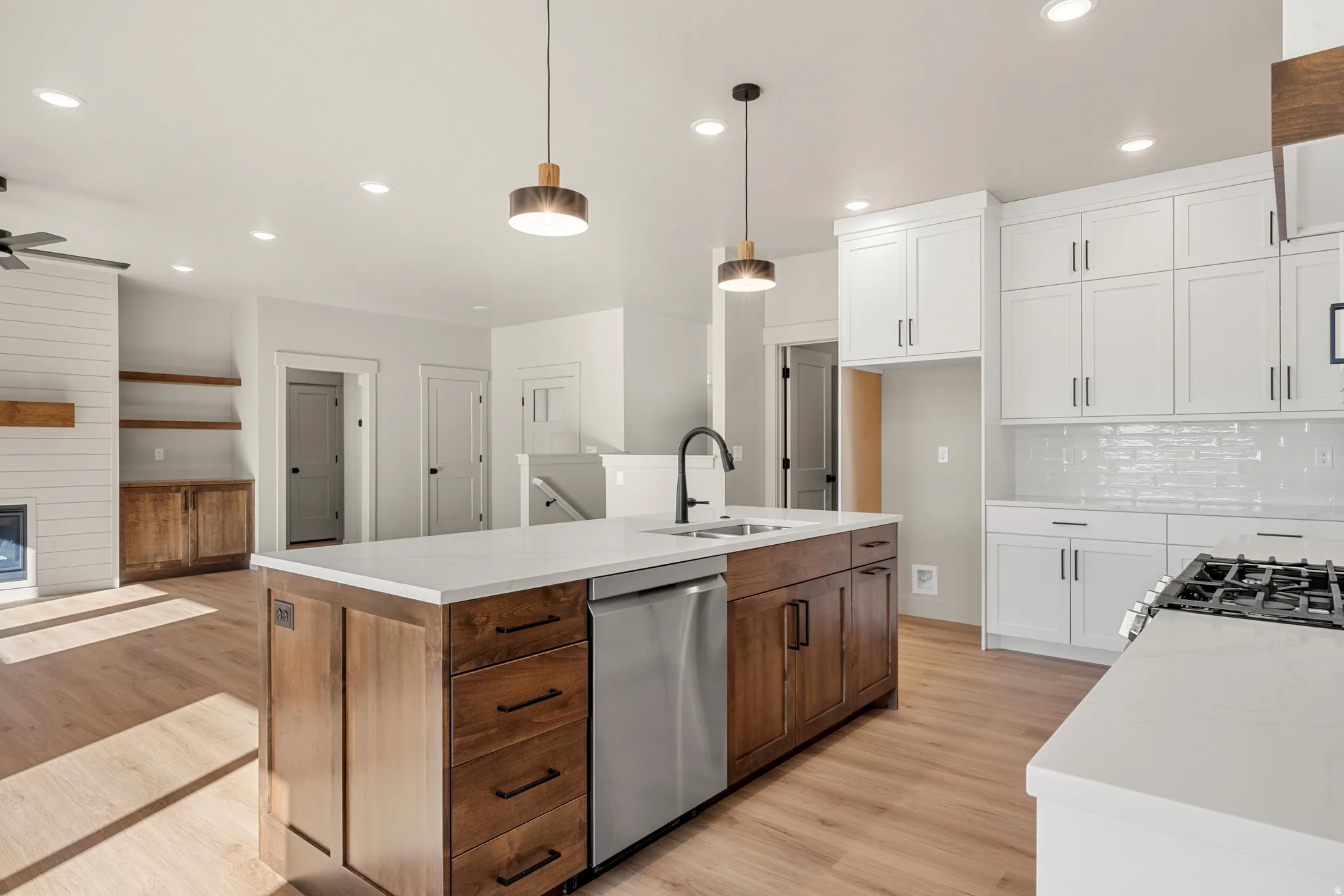 Kitchen featuring white cabinetry, light wood-style flooring, an island with sink, and recessed lighting