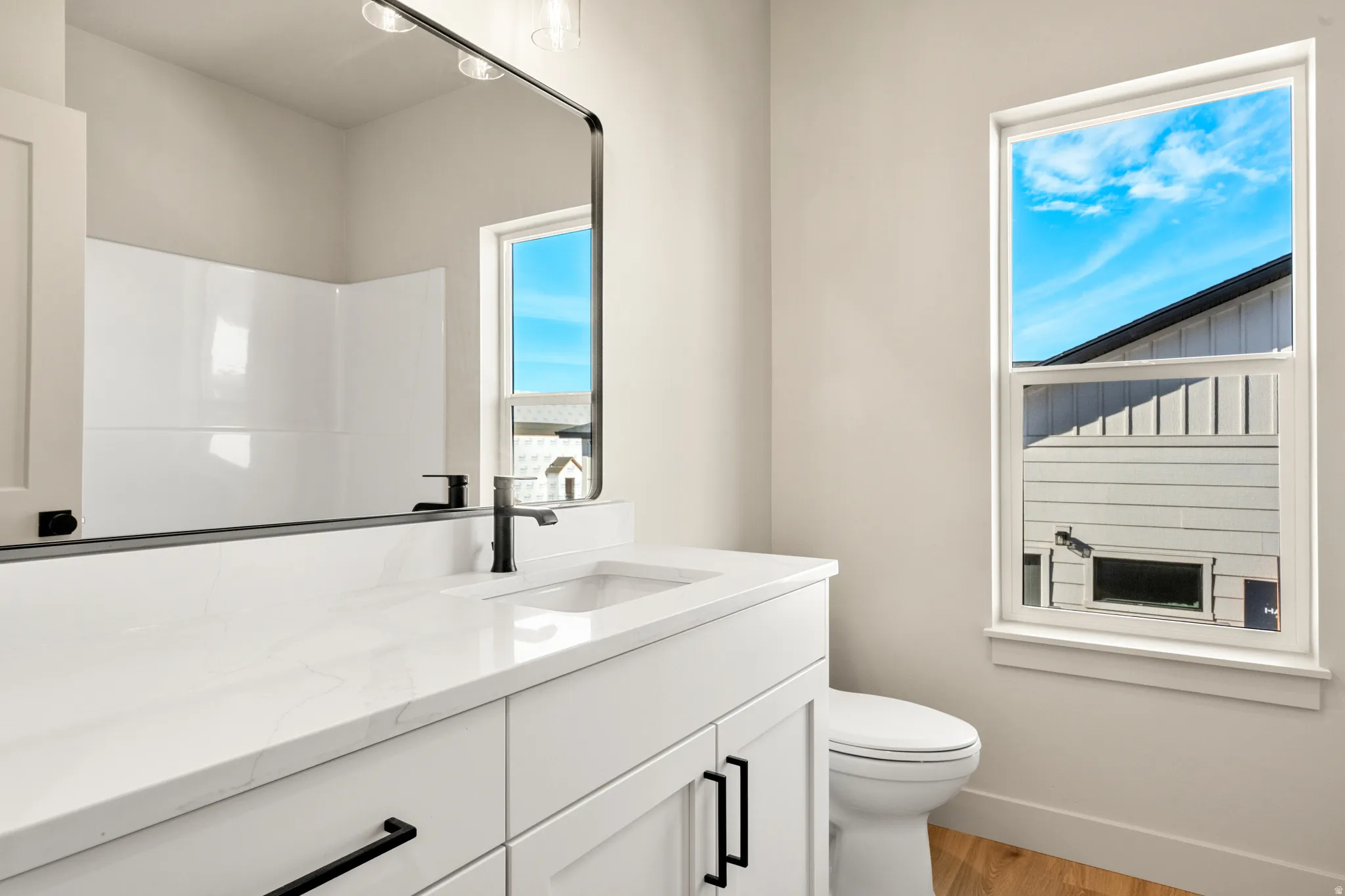 Bathroom featuring vanity, light wood-style flooring, and a shower