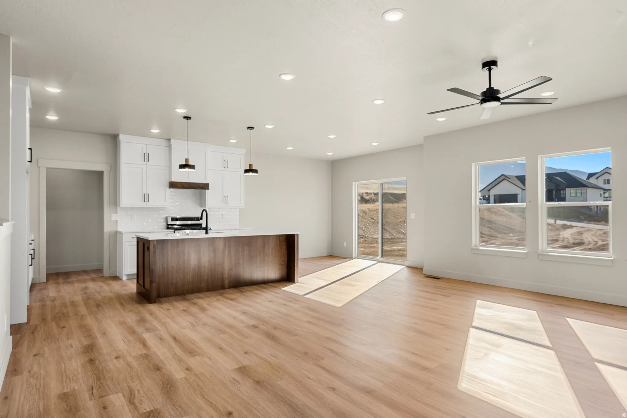 Kitchen with open floor plan, a kitchen island with sink, decorative backsplash, white cabinets, and recessed lighting