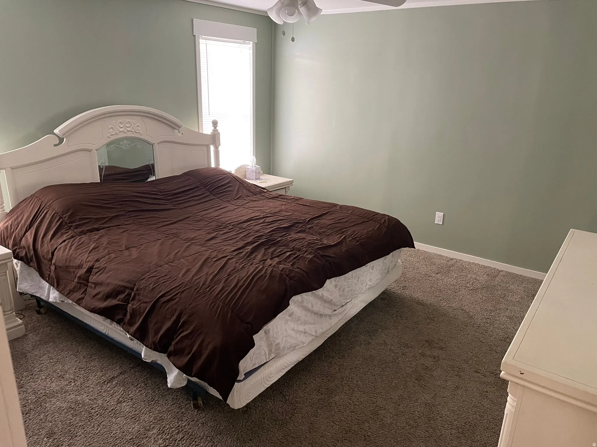 Carpeted bedroom with baseboards and ceiling fan