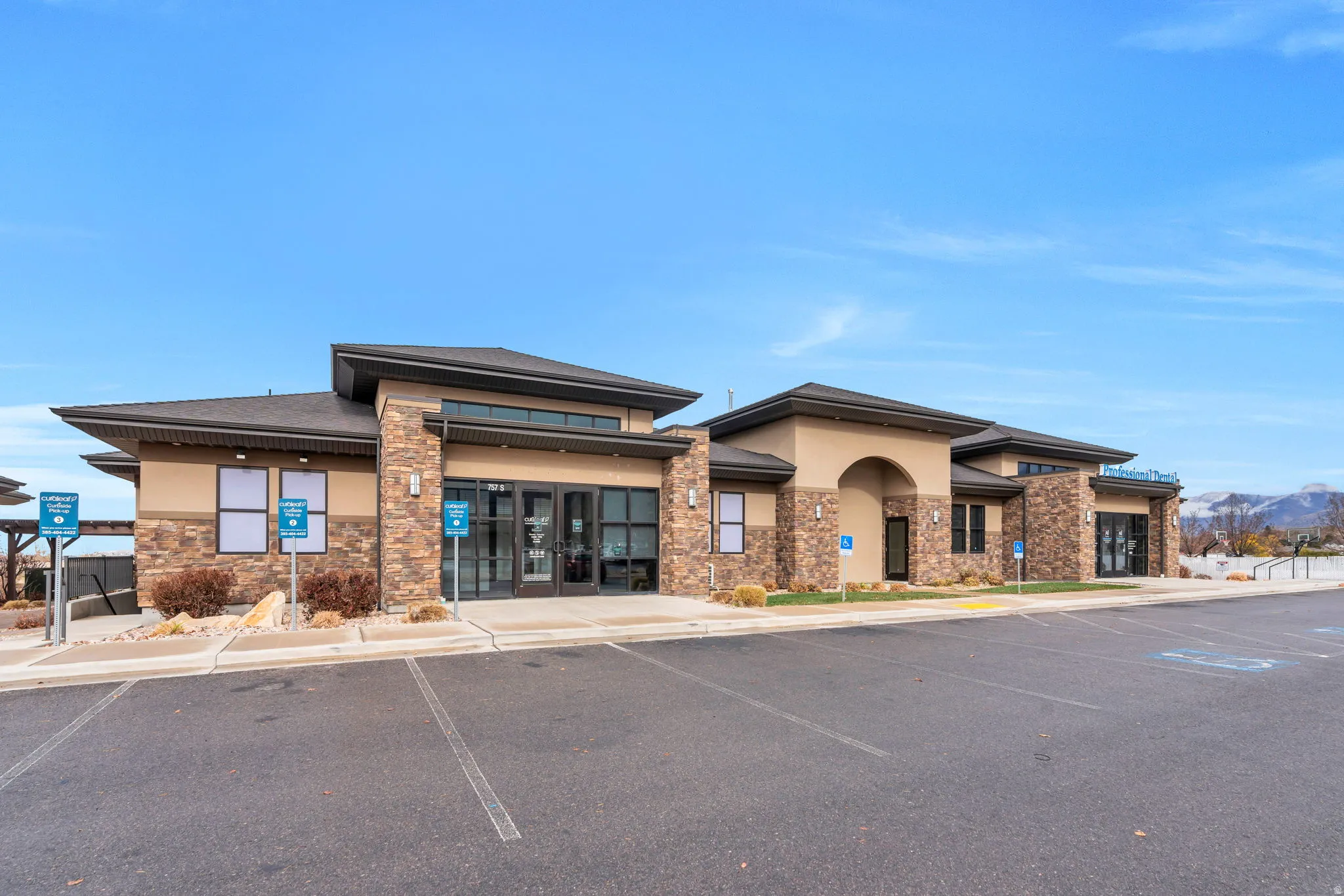 View of property with uncovered parking and a mountain view
