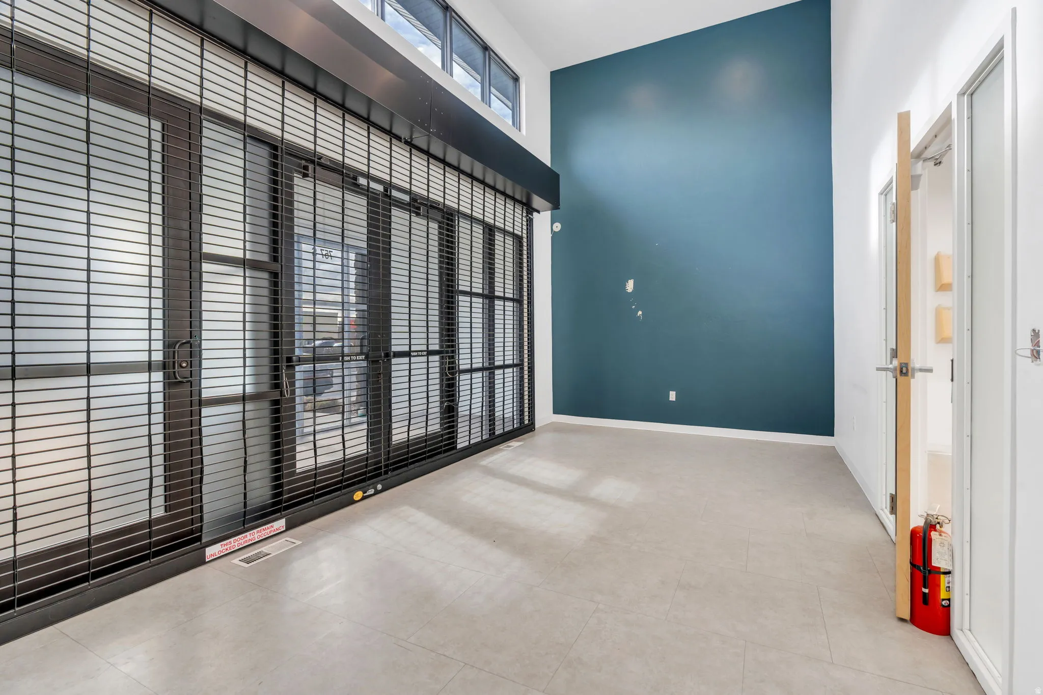 Unfurnished room featuring a towering ceiling and light tile patterned floors