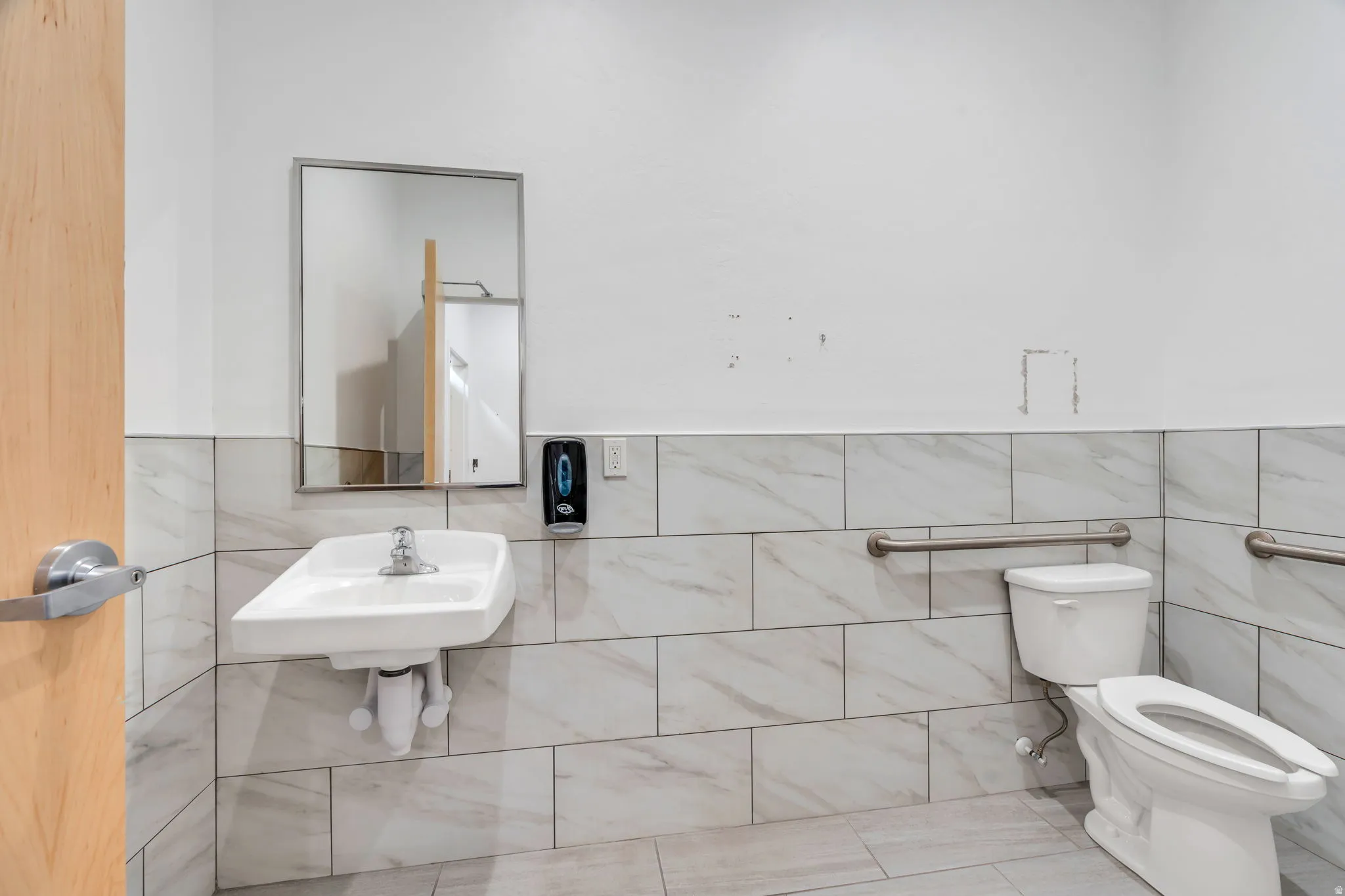 Bathroom featuring tile walls, a wainscoted wall, and tile patterned flooring