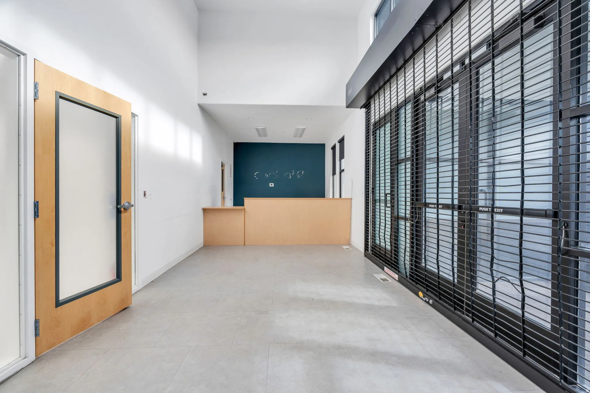 Hallway with a towering ceiling and tile patterned flooring