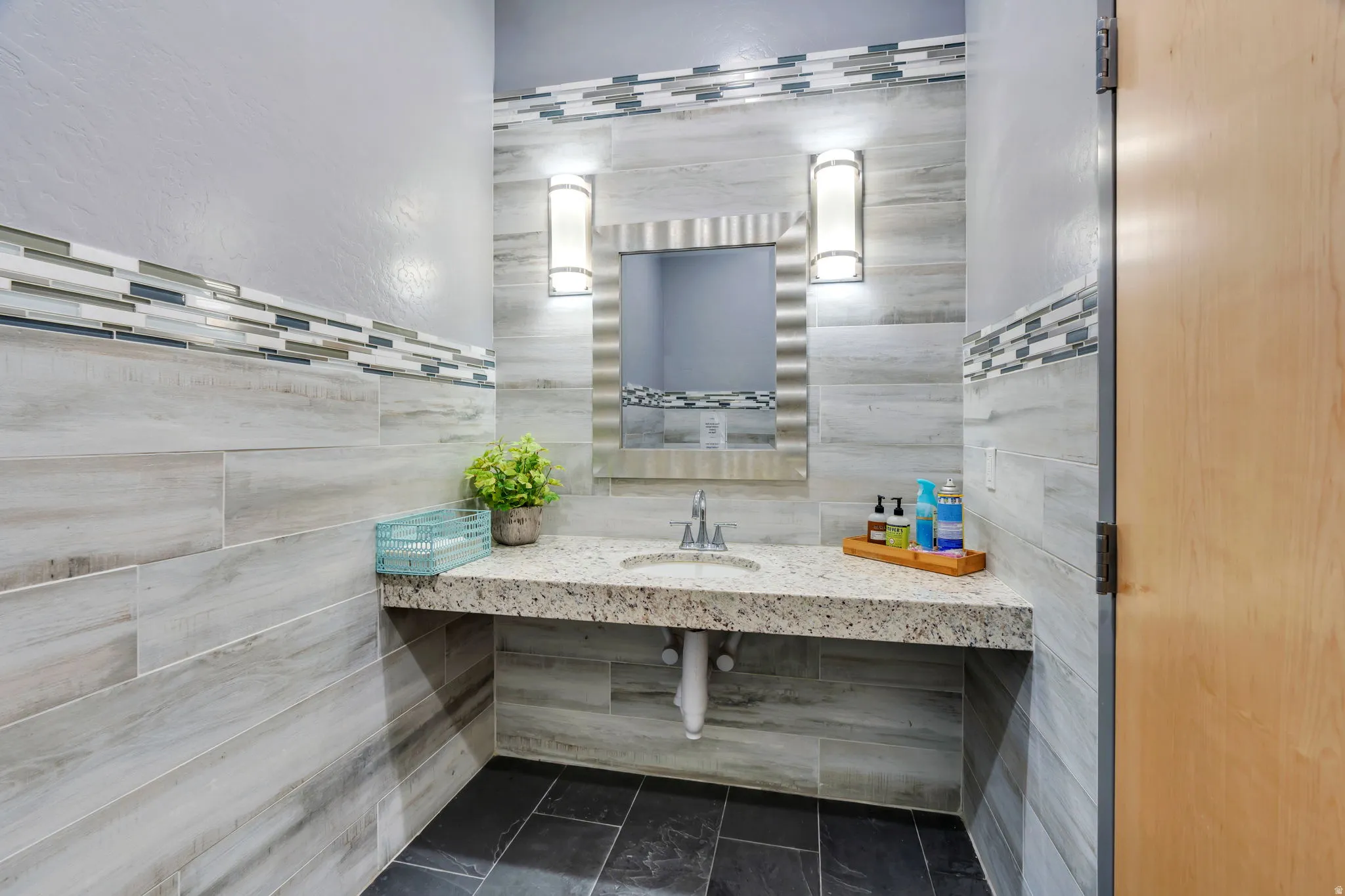 Bathroom with vanity and tile walls