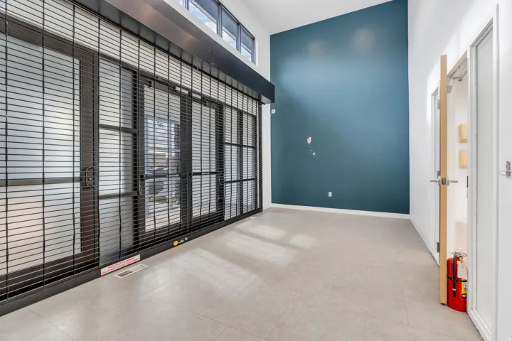 Unfurnished room featuring a towering ceiling and light tile patterned floors