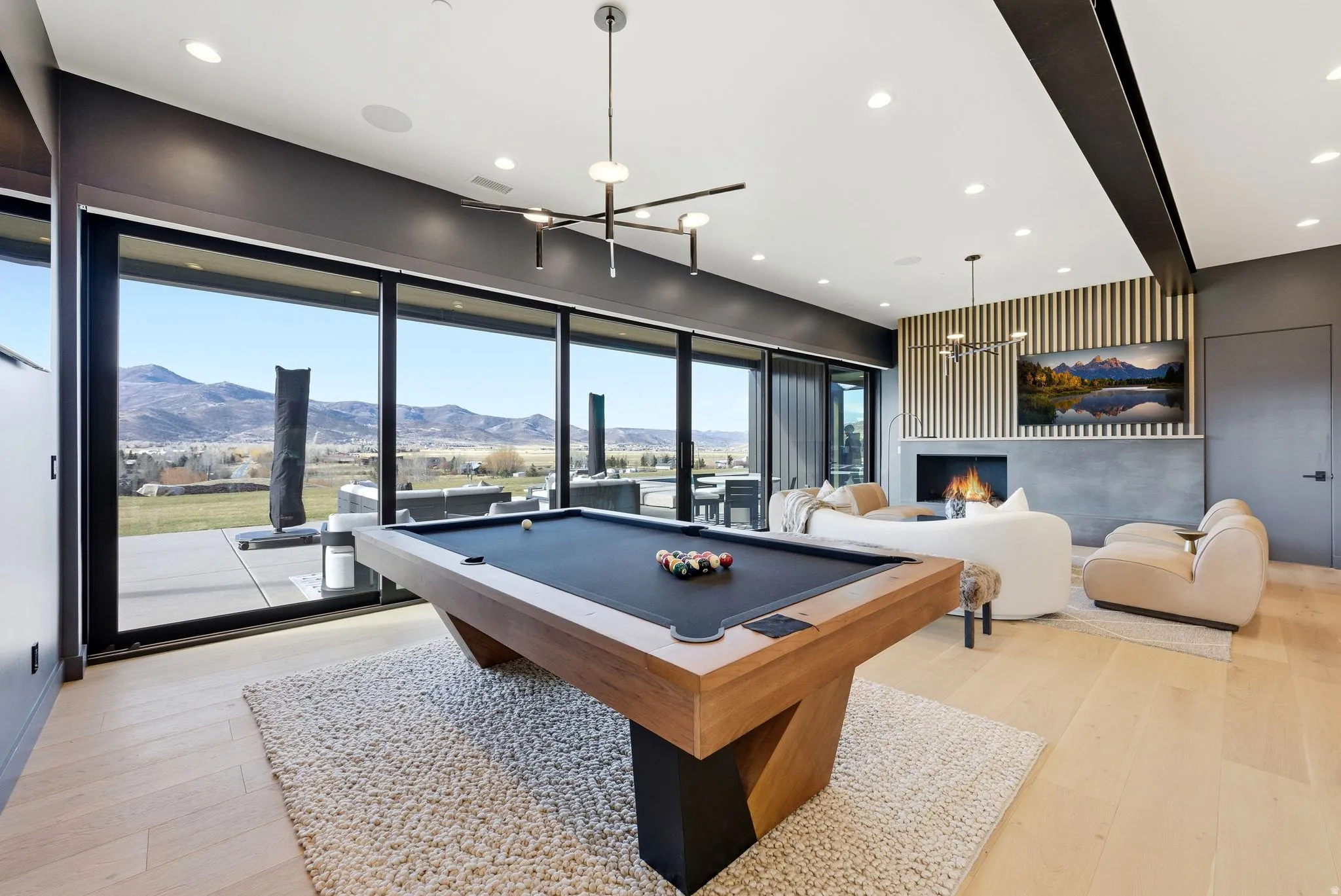 Rec room with billiards table, a mountain view, light wood-style flooring, recessed lighting, and a chandelier