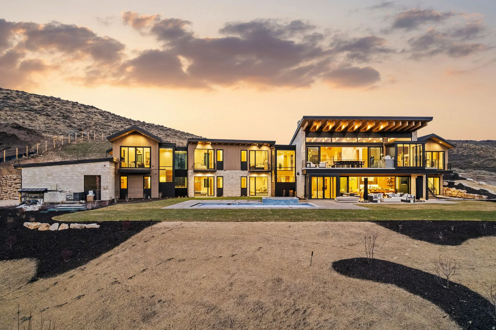 Back of house featuring a balcony, a patio, a hot tub, and a mountain view