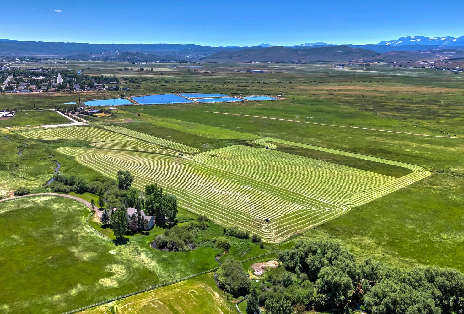Aerial view of property and surrounding area with rural landscape, extensive farmland, and a mountain backdrop