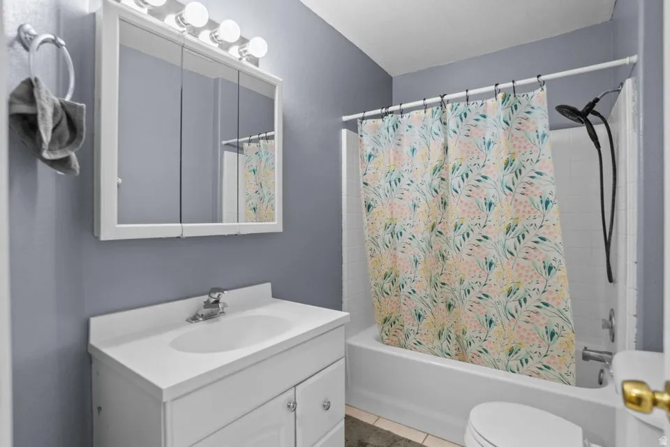 Full bath featuring shower / tub combo, vanity, and light tile patterned flooring