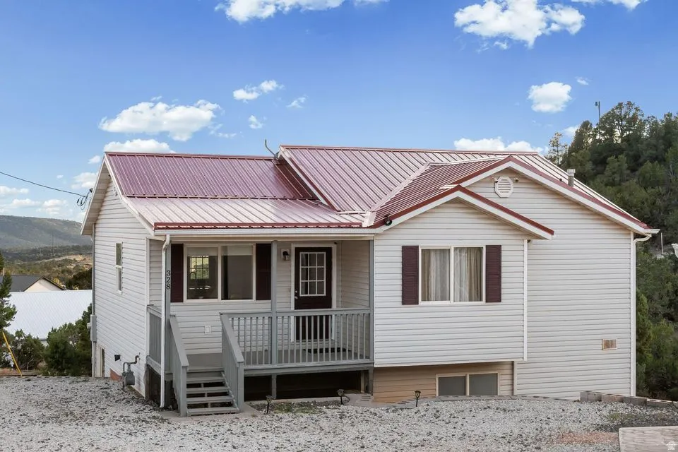 View of front of property with covered porch and a metal roof