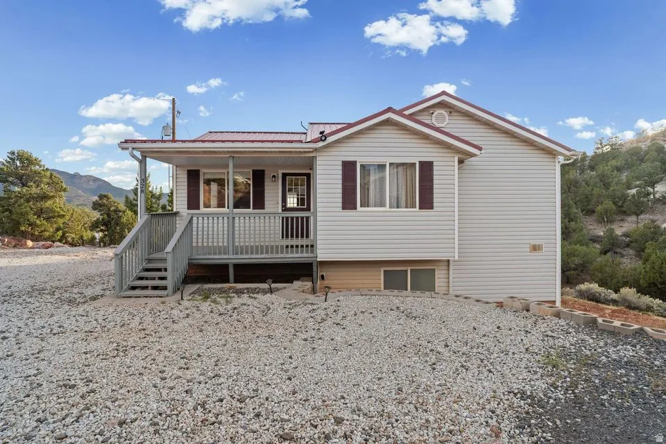 Single story home featuring a porch, a metal roof, and a mountain view
