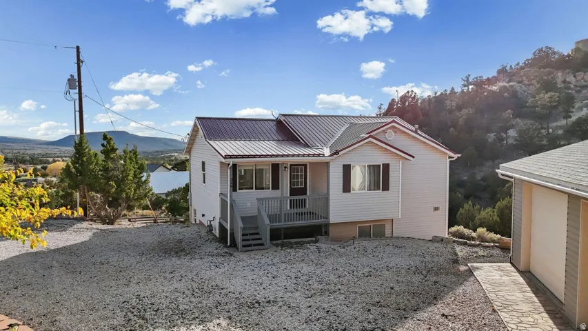 View of front of home with a mountain view, a metal roof, and a porch