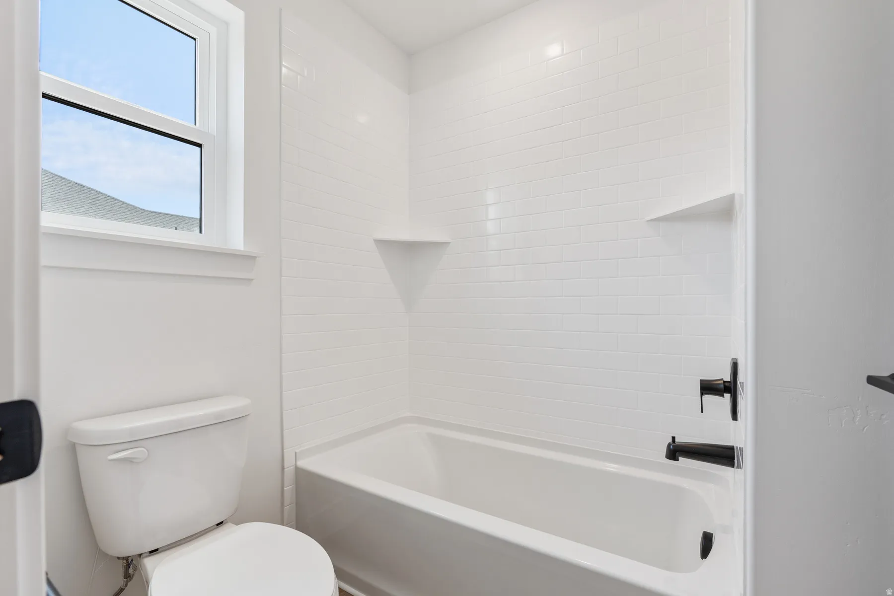Bathroom featuring toilet and washtub / shower combination
