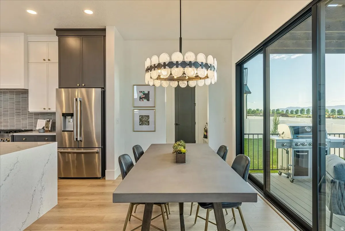 Dining space with light wood-style floors, recessed lighting, and a chandelier