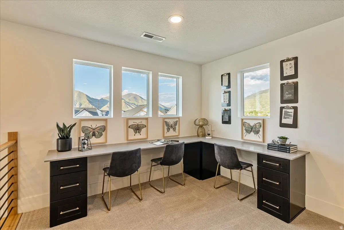 Loft space featuring built in desk, light colored carpet, a textured ceiling, and recessed lighting