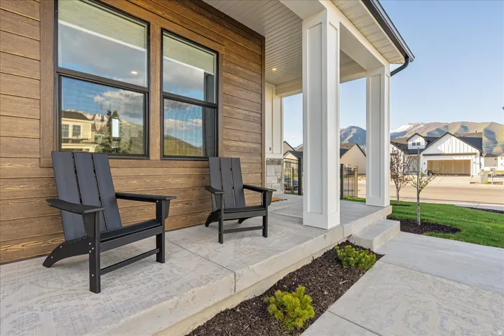 Covered porch with a residential view and a mountain view